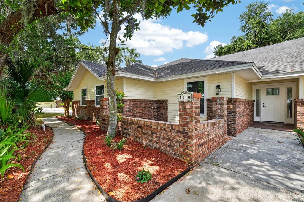 A single-story house with yellow siding, a brick facade, and a concrete walkway — 1510 N BEACH STREET, ORMOND BEACH, FL