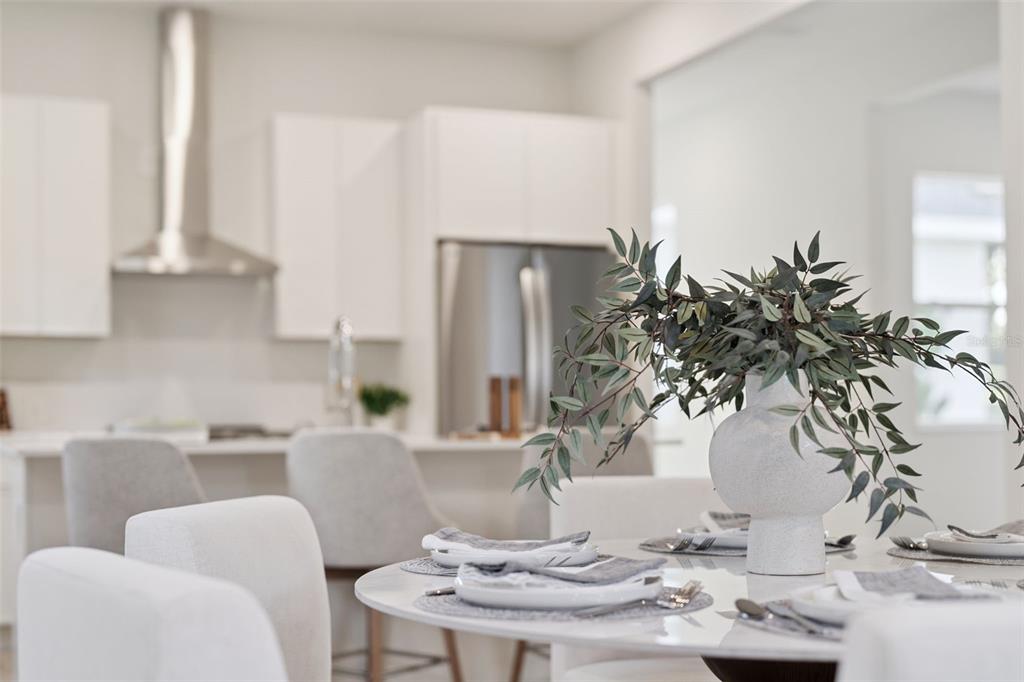A dining area with a round table and chairs sits in front of a modern kitchen — 447 SKYFIELD COURT, LADY LAKE, FL