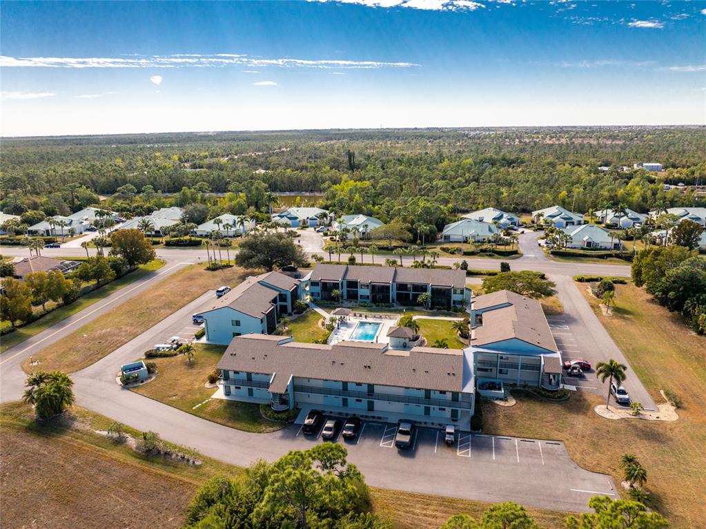 An aerial view of a multi-story apartment complex with a central pool and parking lot — 301 ISLAMORADA BOULEVARD UNIT 22B, PUNTA GORDA, FL