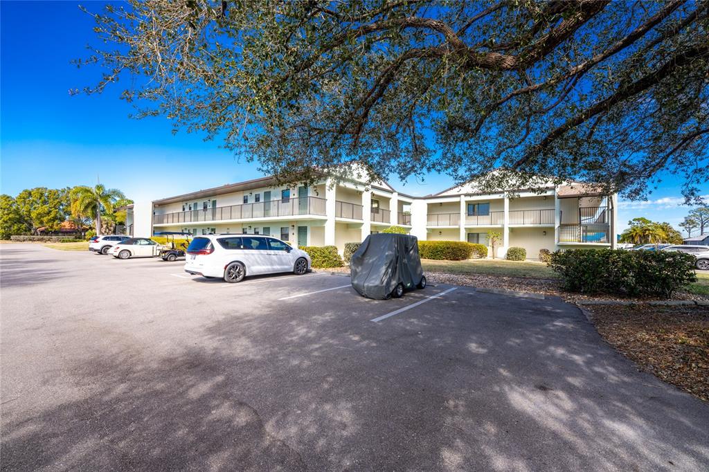 A two-story apartment building with a parking lot and a covered golf cart — 301 ISLAMORADA BOULEVARD UNIT 22B, PUNTA GORDA, FL