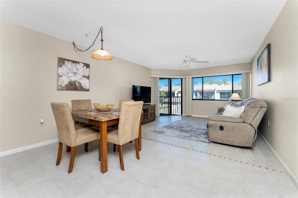A dining area and living room with tile floors, a ceiling fan, and sliding glass doors — 301 ISLAMORADA BOULEVARD UNIT 22B, PUNTA GORDA, FL