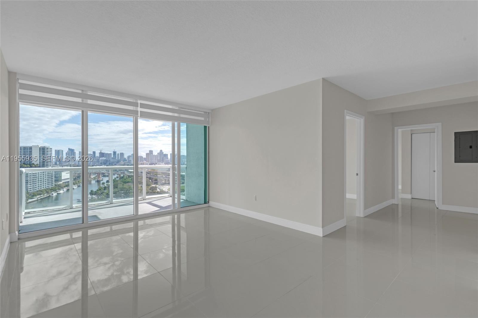 An empty room with light-colored tile floors, white walls, and floor-to-ceiling windows overlooking a city — 1861 NW S River Dr # 2209, Miami FL 33125, MIAMI, FL