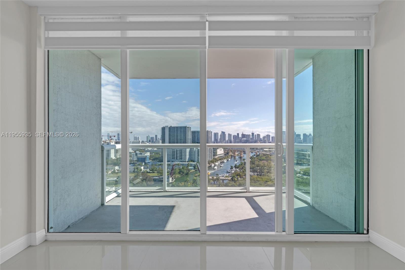 A room with large sliding glass doors opening onto a balcony overlooking a city skyline — 1861 NW S River Dr # 2209, Miami FL 33125, MIAMI, FL