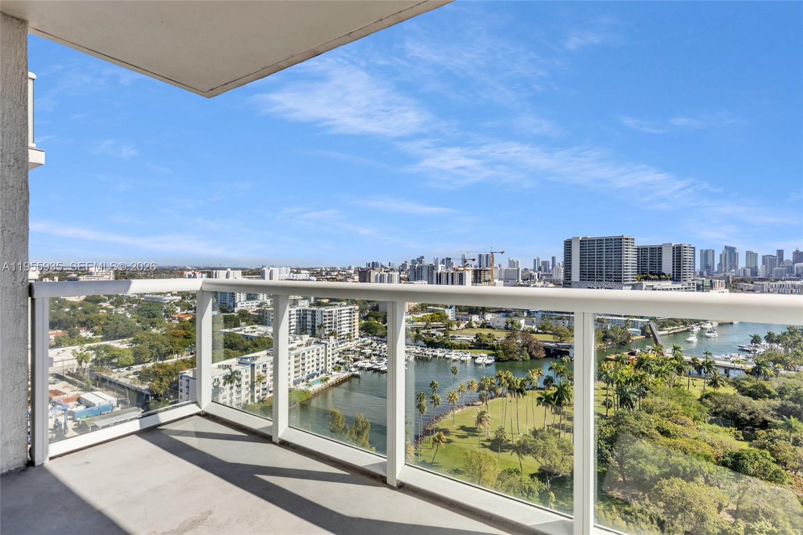 A balcony with a glass railing overlooks a marina, a park, and a city skyline — 1861 NW S River Dr # 2209, Miami FL 33125, MIAMI, FL