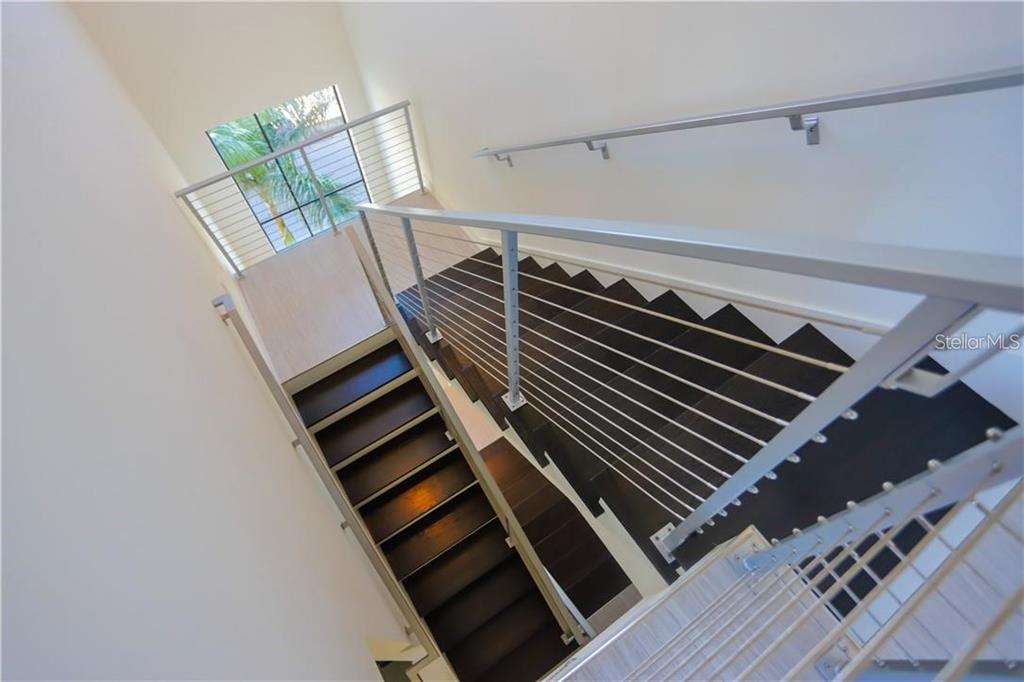 A high-angle view of a modern staircase with dark wood treads and metal railings — 2814 W BARCELONA STREET, TAMPA, FL