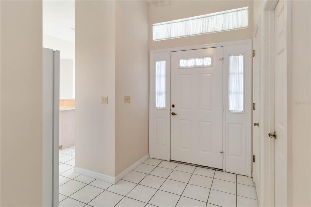 An entryway features white tile flooring, a front door with sidelights, and a transom window — 2911 ELBERT WAY, KISSIMMEE, FL