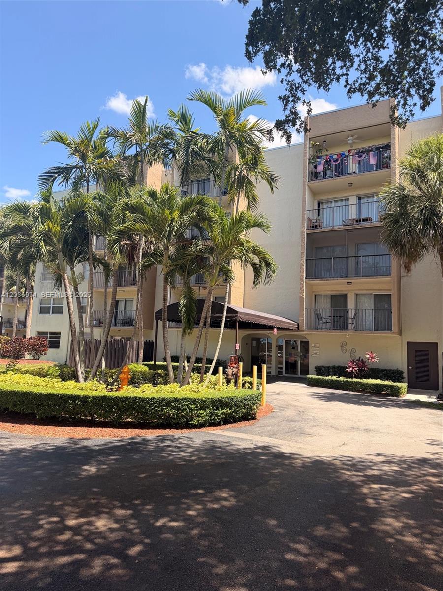 A multi-story apartment building features balconies, palm trees, and a covered entrance — 14250 SW 62nd St # 310, Miami FL 33183, MIAMI, FL