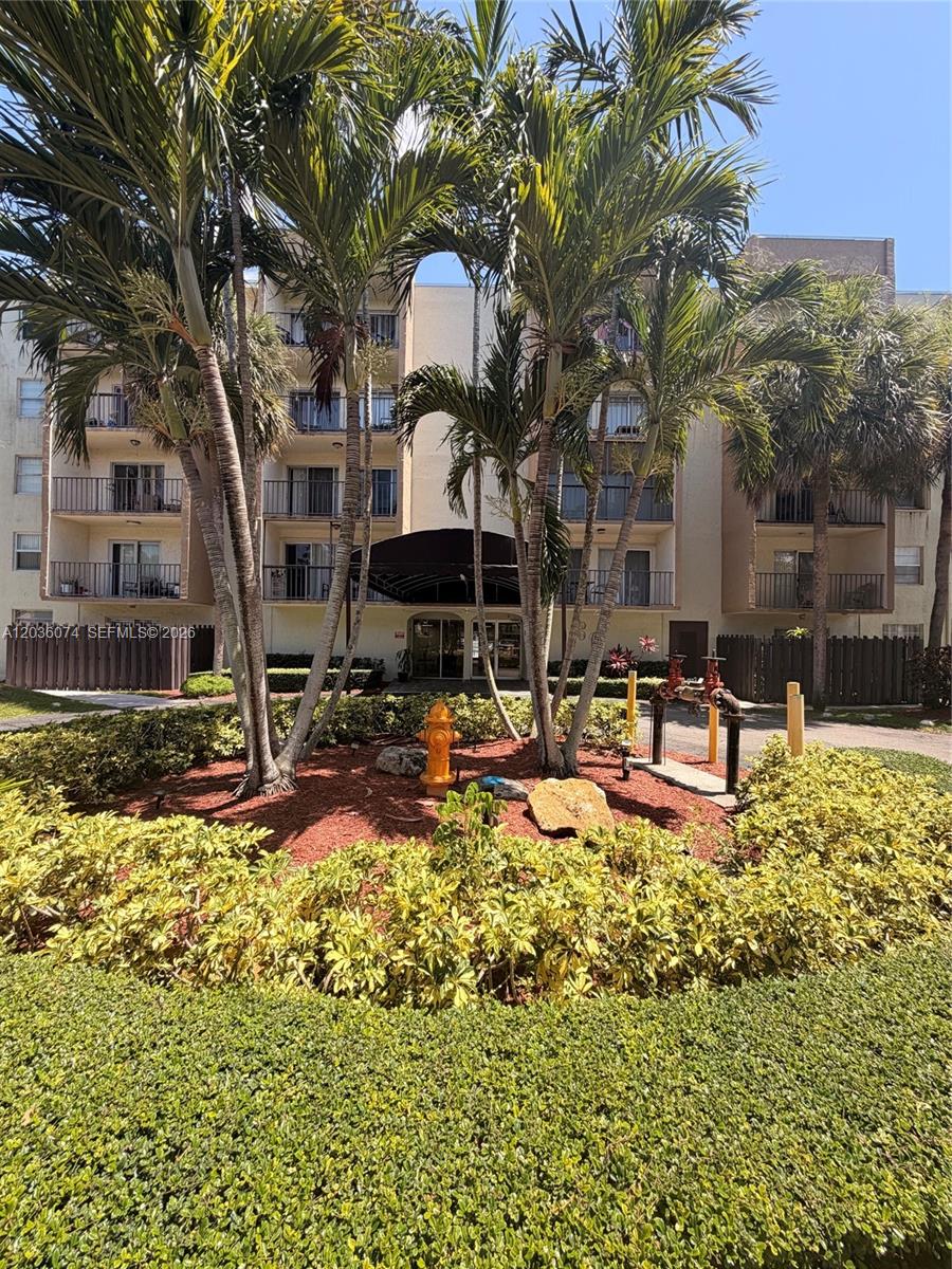 A multi-story apartment building exterior features palm trees, a fire hydrant, and a landscaped garden — 14250 SW 62nd St # 310, Miami FL 33183, MIAMI, FL