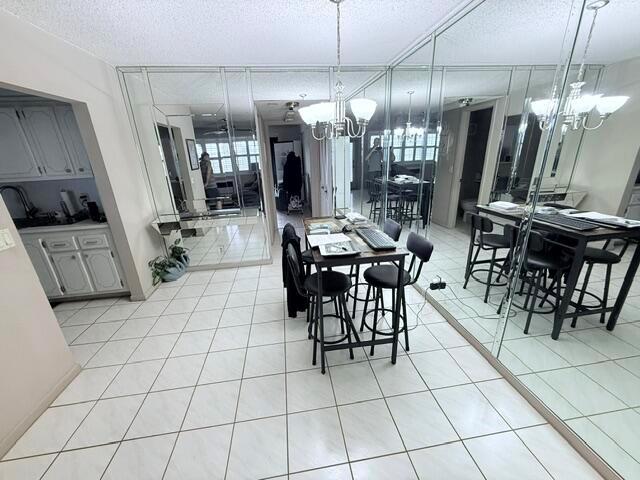 A dining area features a table with chairs, tiled floors, and a mirrored accent wall — 76 Markham D, Deerfield Beach FL 33442, DEERFIELD BEACH, FL