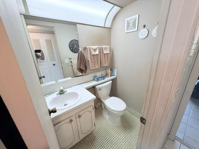 A bathroom features a white vanity, a toilet, and a large mirror above the sink — 76 Markham D, Deerfield Beach FL 33442, DEERFIELD BEACH, FL