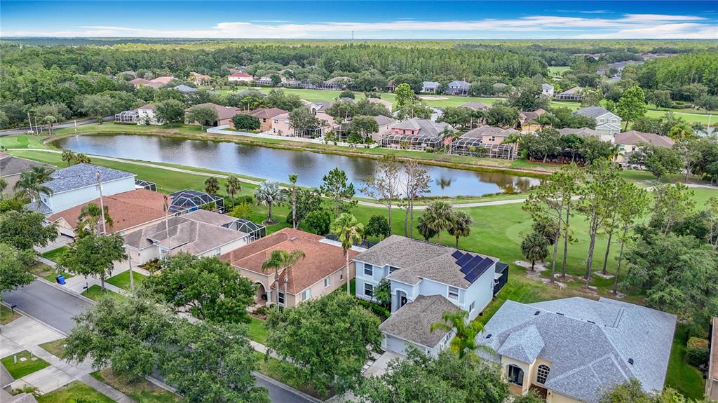 An aerial view of a suburban neighborhood featuring houses with pools near a lake — 18109 KARA COURT, TAMPA, FL