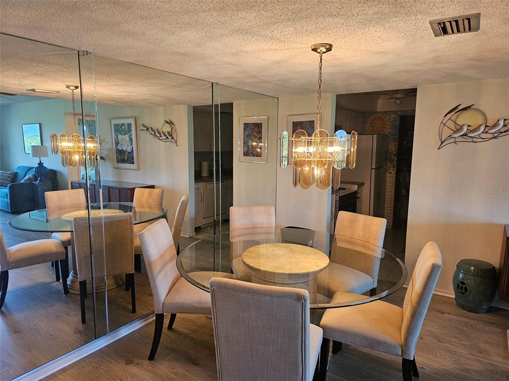 A living room features a blue sofa, a beige loveseat, and a balcony with golf course views — 4119 61ST AVENUE TERRACE W UNIT 404, BRADENTON, FL