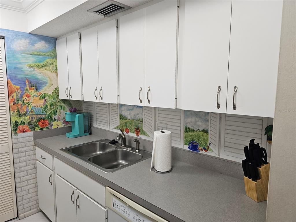 A kitchen features white cabinets, a black microwave, a white stove, and a refrigerator — 4119 61ST AVENUE TERRACE W UNIT 404, BRADENTON, FL
