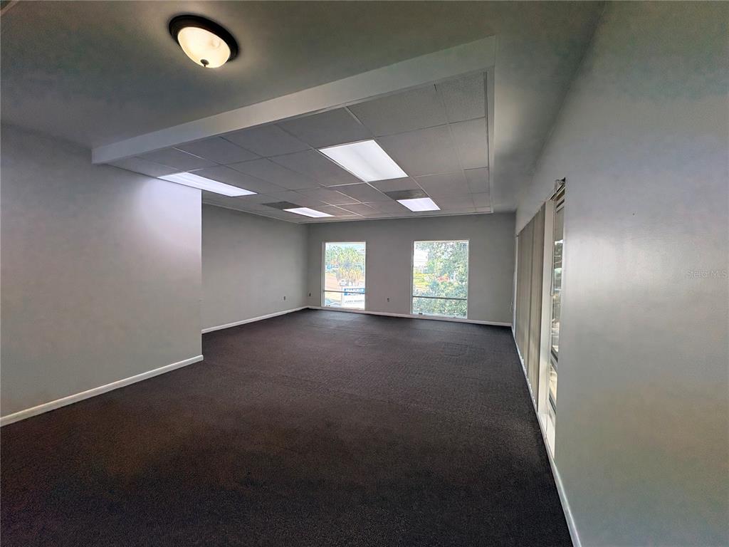An empty office space with gray walls, dark carpeting, and a drop ceiling with lights — 2110 DREW STREET (2nd floor), CLEARWATER, FL