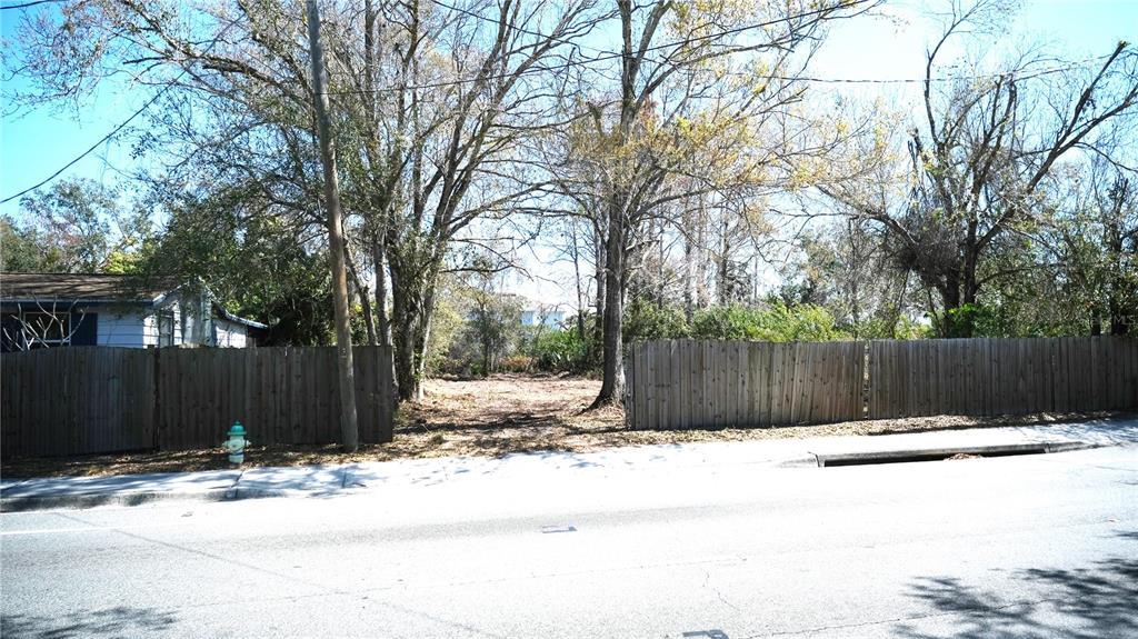 A vacant, wooded residential lot is situated between two wooden privacy fences along a street — 00 N LOCKWOOD RIDGE ROAD, SARASOTA, FL