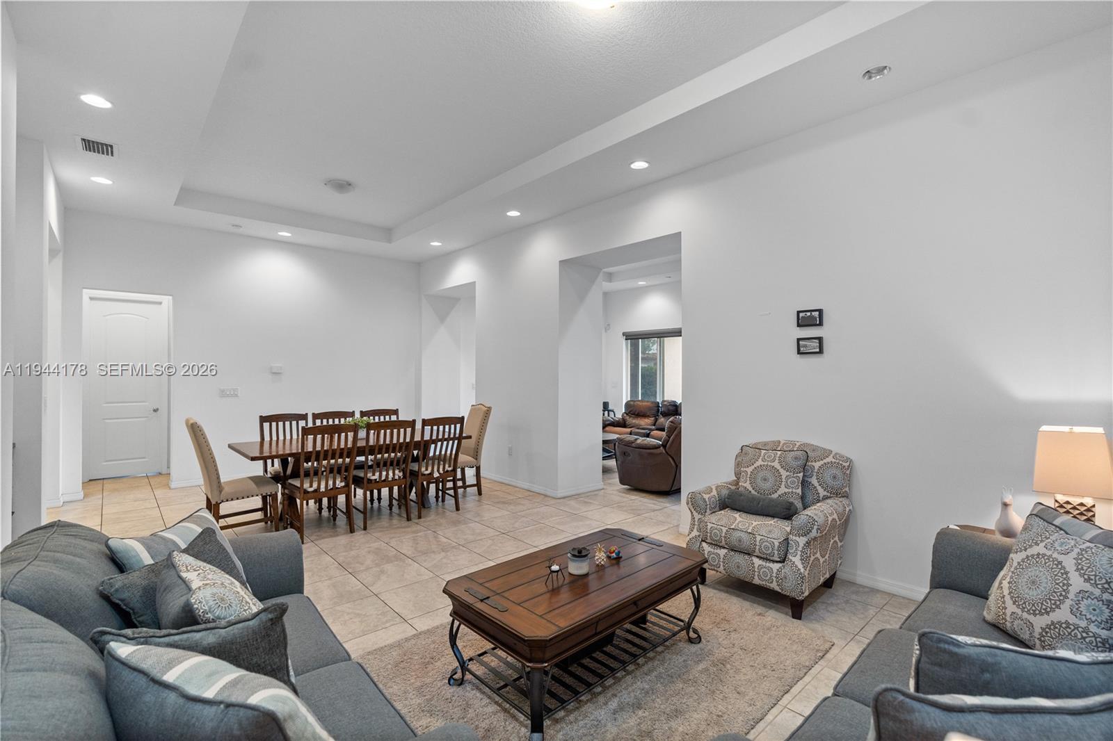 A living room and dining area feature tile flooring, recessed lighting, and neutral walls — 15102 SW 177th Ter, Miami FL 33187, MIAMI, FL
