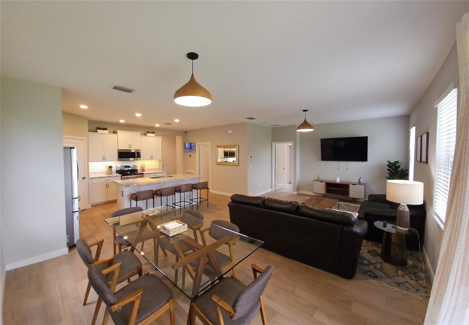 An open-concept living area features a kitchen with an island, dining space, and living room — 3034 NE Skyview Lane, Jensen Beach FL 34957, JENSEN BEACH, FL