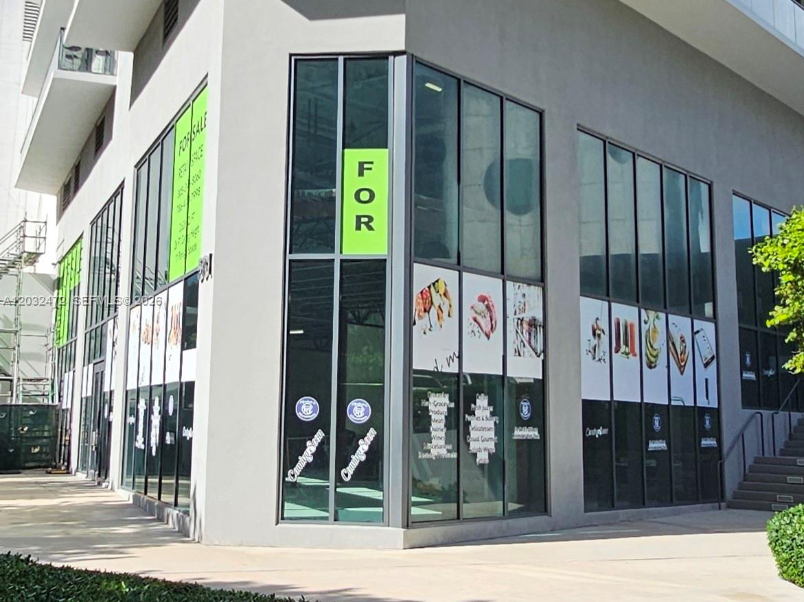 A modern commercial building corner features floor-to-ceiling windows with signage and coming soon decals — 501 NE 31st St # 1, Miami FL 33137, MIAMI, FL