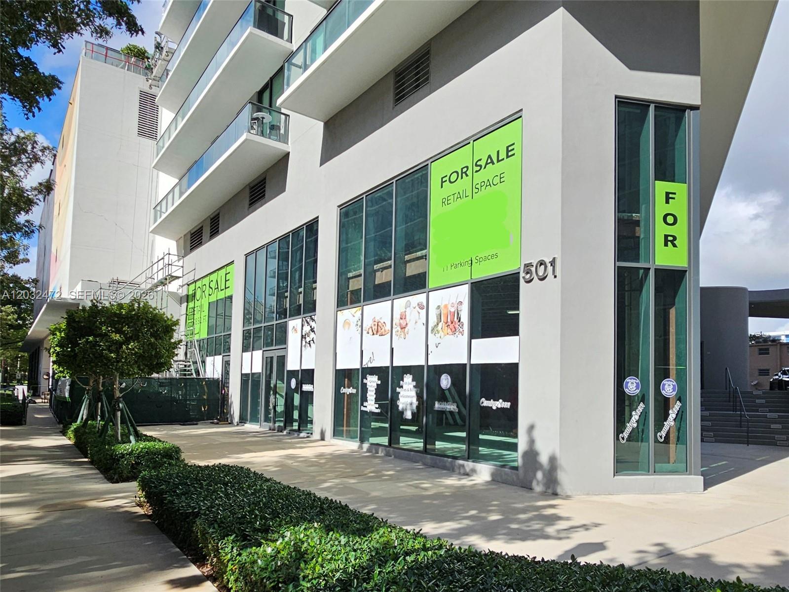 A modern multi-story building features ground-floor retail space for sale with large glass windows — 501 NE 31st St # 1, Miami FL 33137, MIAMI, FL