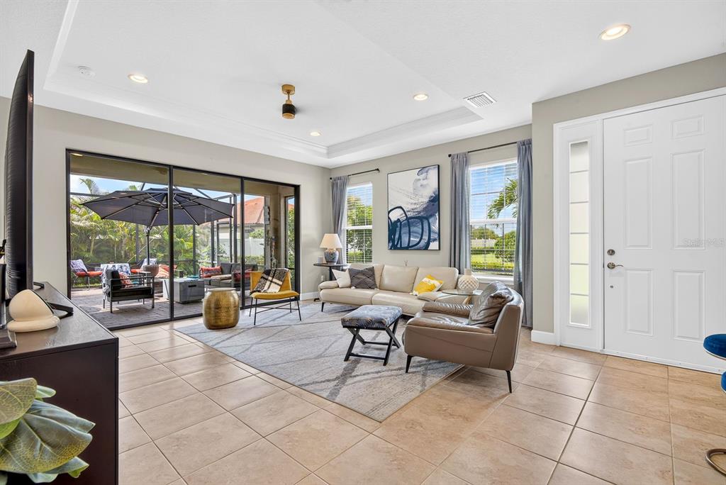 A living room with tile floors, a large area rug, and sliding doors to a patio — 5319 TALIAFERRO COURT, PALMETTO, FL