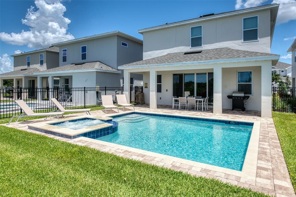 An outdoor water park with slides and a pool surrounded by palm trees and houses — 7763 WESTLAND DRIVE, KISSIMMEE, FL
