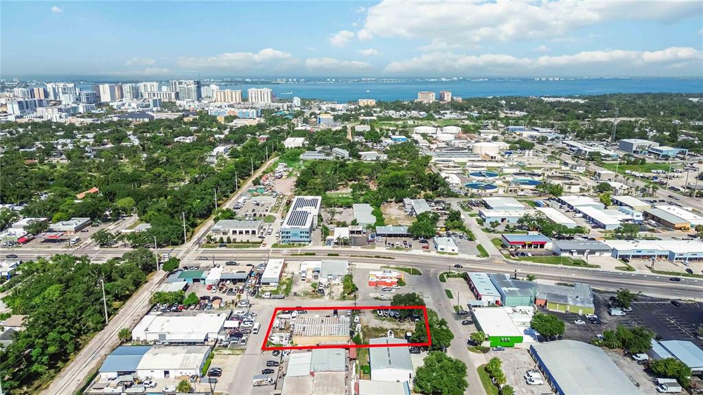 An aerial view shows a commercial property outlined in red within a suburban landscape — 2011 CORNELL STREET, SARASOTA, FL