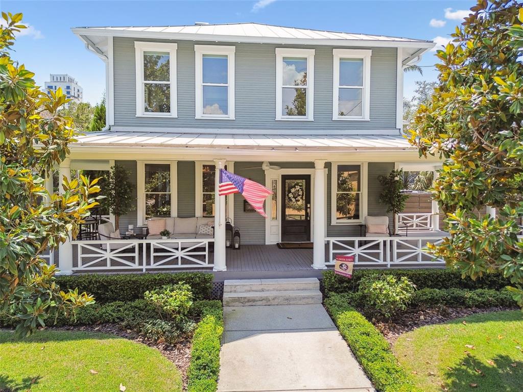 A two-story house with a covered front porch, white railings, and light blue siding — 1411 S ALBANY AVENUE, TAMPA, FL
