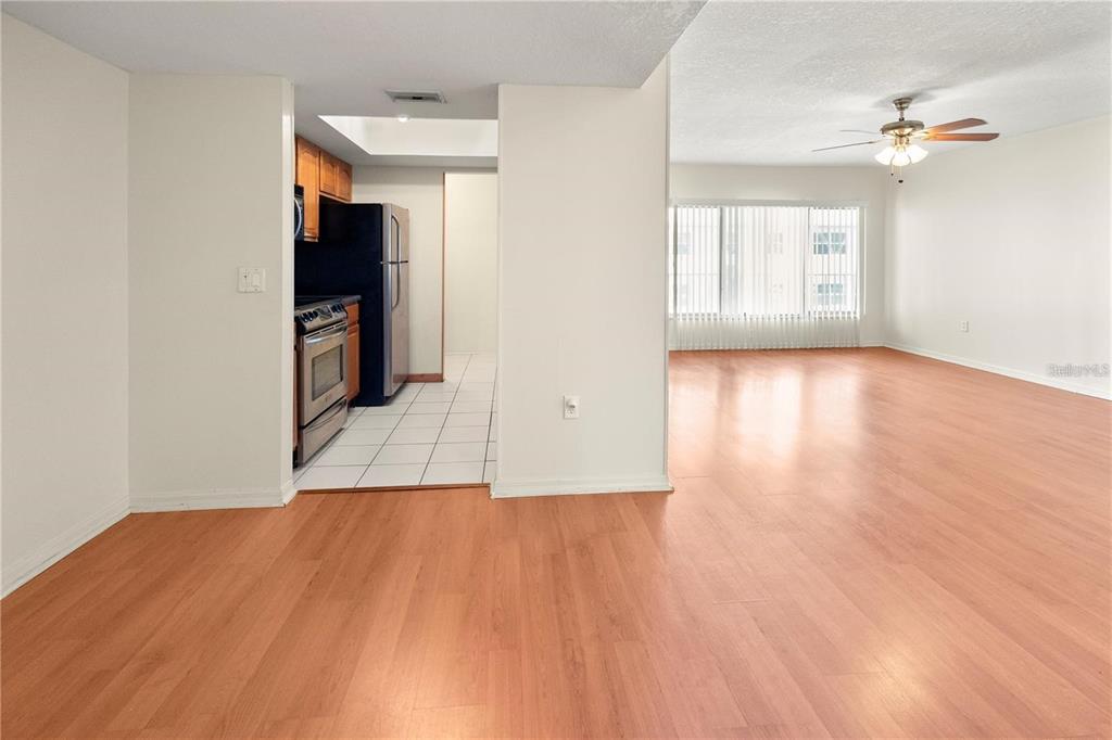 A view of a kitchen with tile flooring adjacent to a large living area — 22278 VICK STREET UNIT A112, PUNTA GORDA, FL