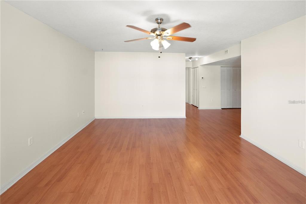 An empty room with light wood-look flooring, white walls, and a ceiling fan — 22278 VICK STREET UNIT A112, PUNTA GORDA, FL
