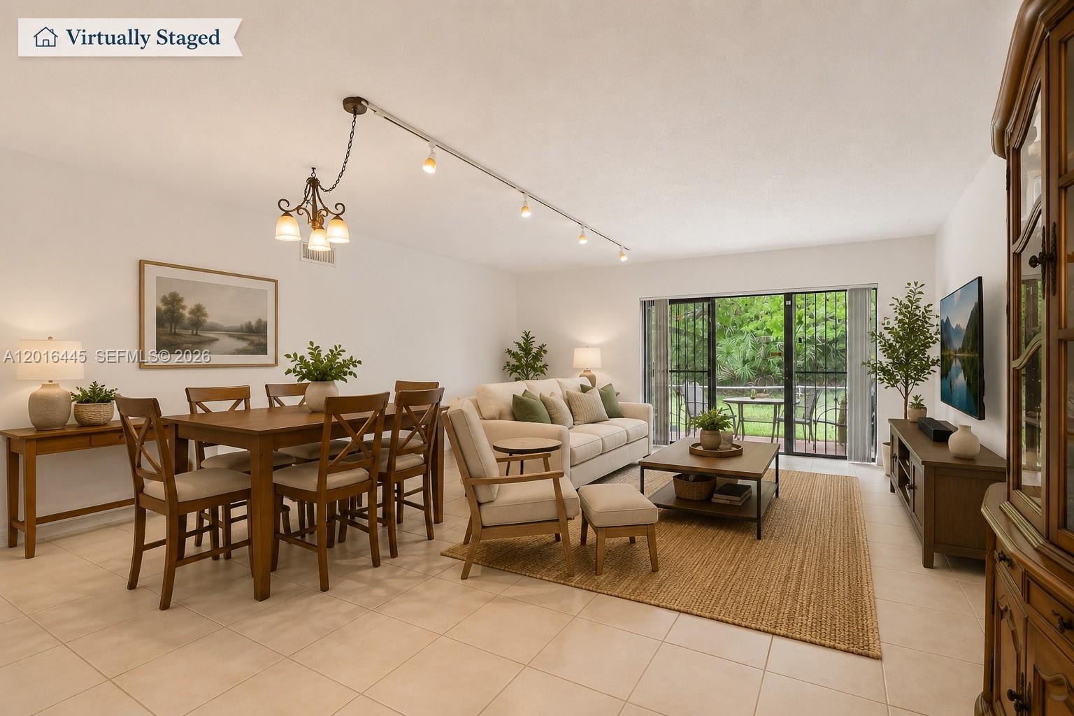 This virtually staged living and dining room features tile flooring, track lighting, and sliding glass doors — 425 W Park Dr # 10, Miami FL 33172, MIAMI, FL