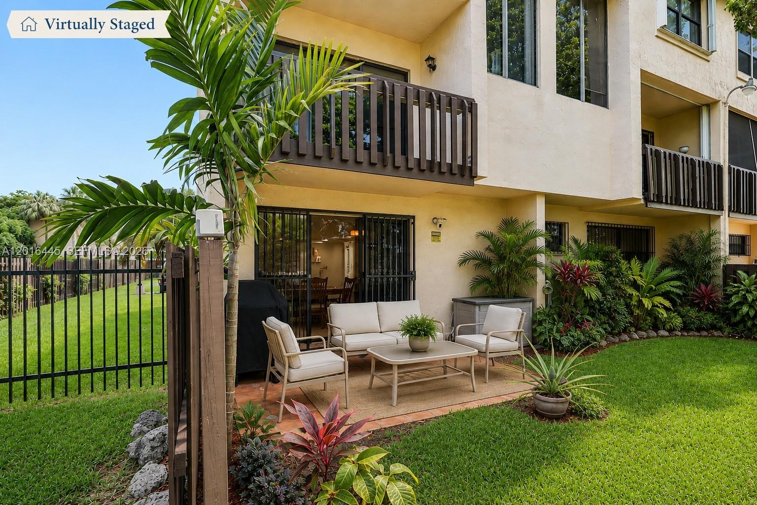 A patio with outdoor furniture sits on a lawn outside a two-story residential building — 425 W Park Dr # 10, Miami FL 33172, MIAMI, FL