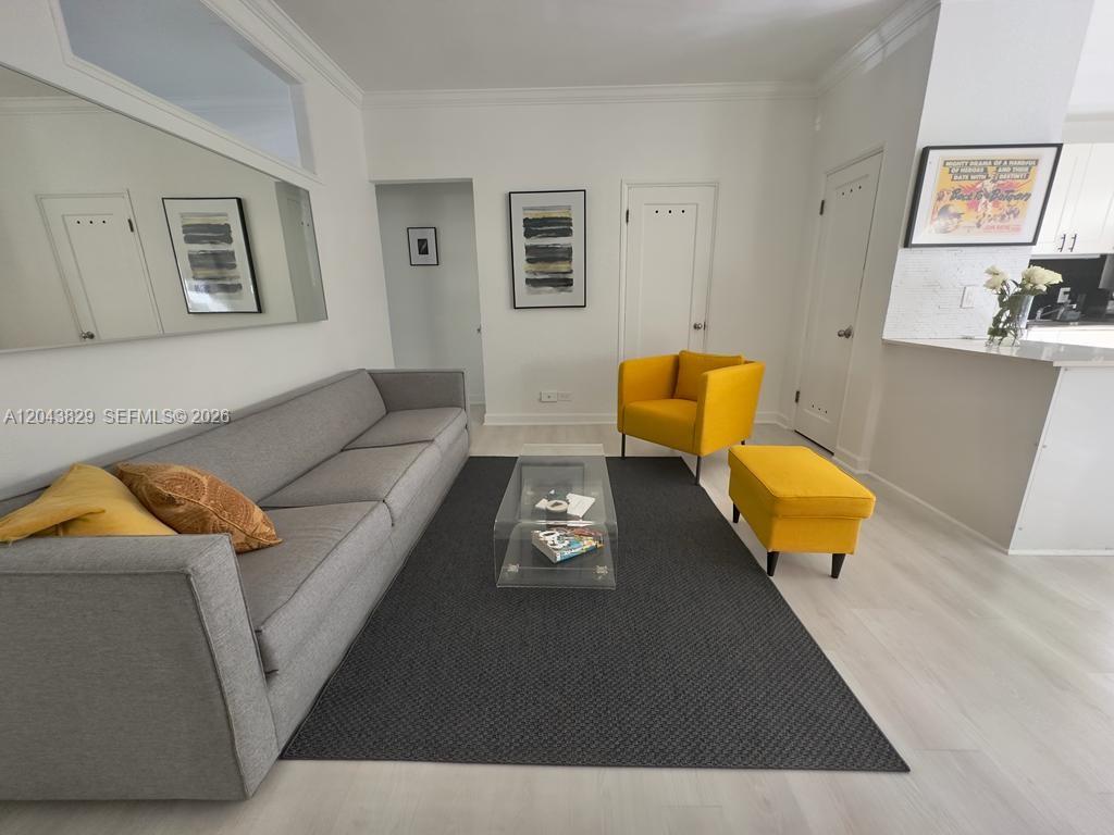 A living room features a gray sofa, yellow accent chairs, and a dark area rug — 836 10th St # 5, Miami Beach FL 33139, MIAMI BEACH, FL