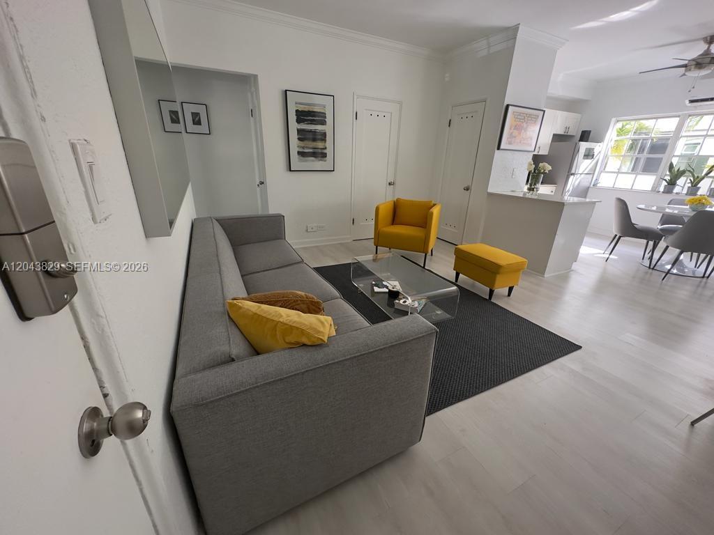 A living room features a gray sofa, yellow accent chairs, and light wood flooring — 836 10th St # 5, Miami Beach FL 33139, MIAMI BEACH, FL