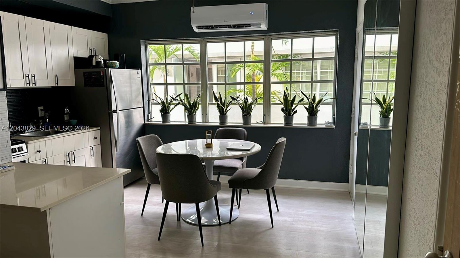 A kitchen and dining area features white cabinets, a round table, and large windows — 836 10th St # 5, Miami Beach FL 33139, MIAMI BEACH, FL