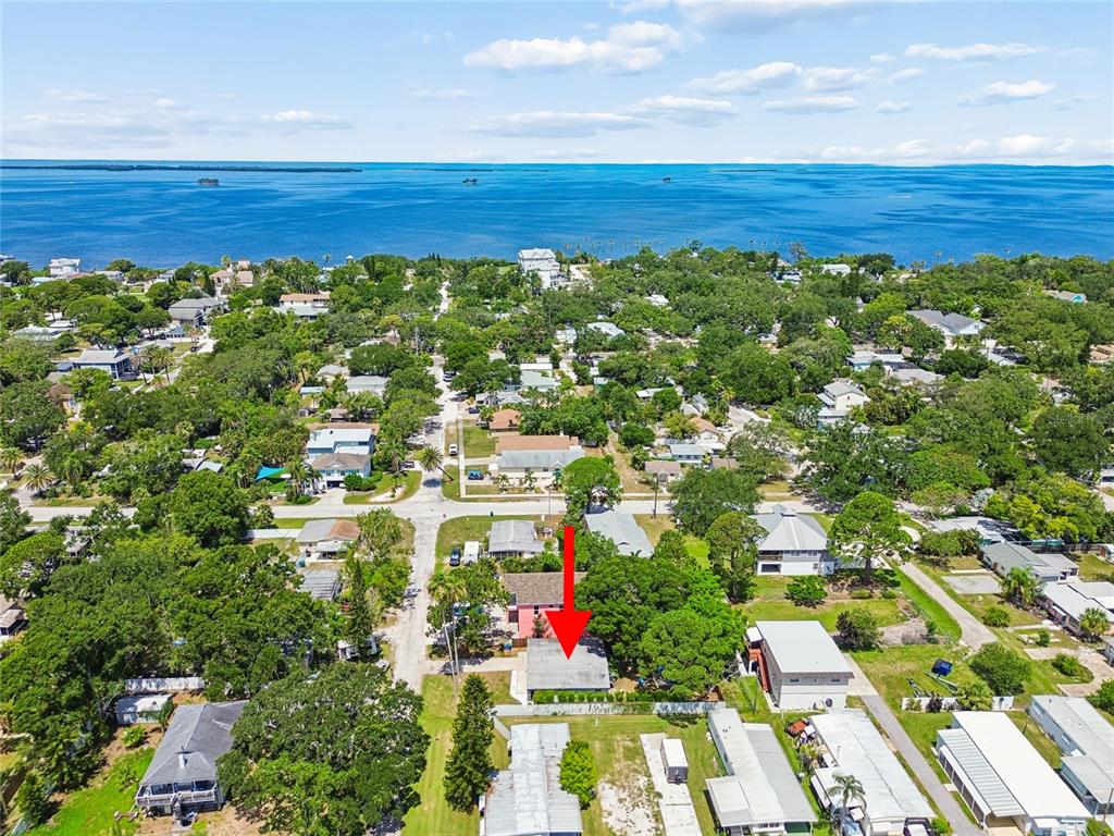 An aerial view shows a residential neighborhood with a red arrow pointing to a house — 314 INDIANA AVENUE, CRYSTAL BEACH, FL