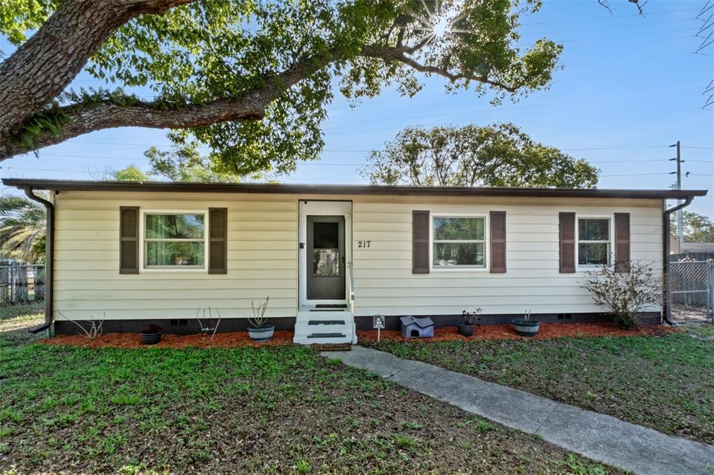 A single-story house with light-colored horizontal siding, dark shutters, and a front entrance — 217 COLONY DRIVE, CASSELBERRY, FL