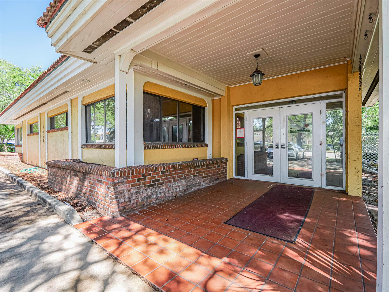 The exterior entrance features a brick planter, tiled porch, and double glass doors — 3660 20th Street, Vero Beach FL 32960, VERO BEACH, FL