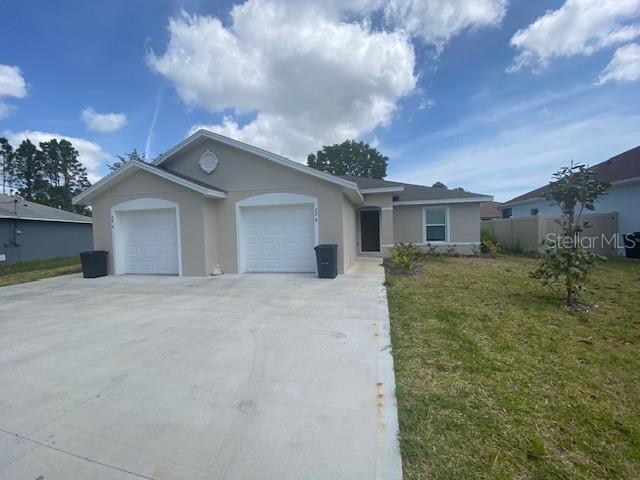 A single-story duplex with two garage doors and a concrete driveway under a blue sky — 20 BUTTONWOOD LANE, PALM COAST, FL