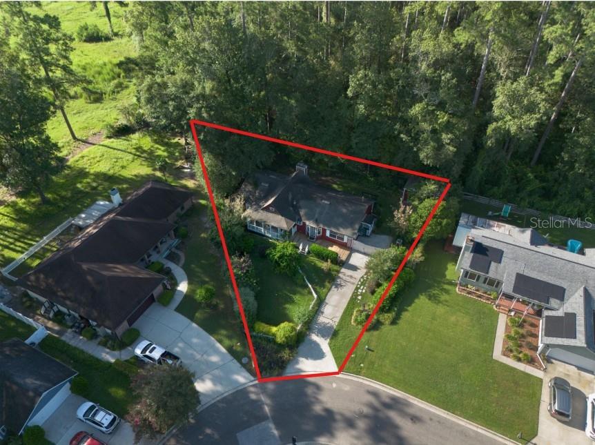 An aerial view shows a house with a red outline highlighting its triangular-shaped residential lot — 10709 NW 31ST PLACE, GAINESVILLE, FL