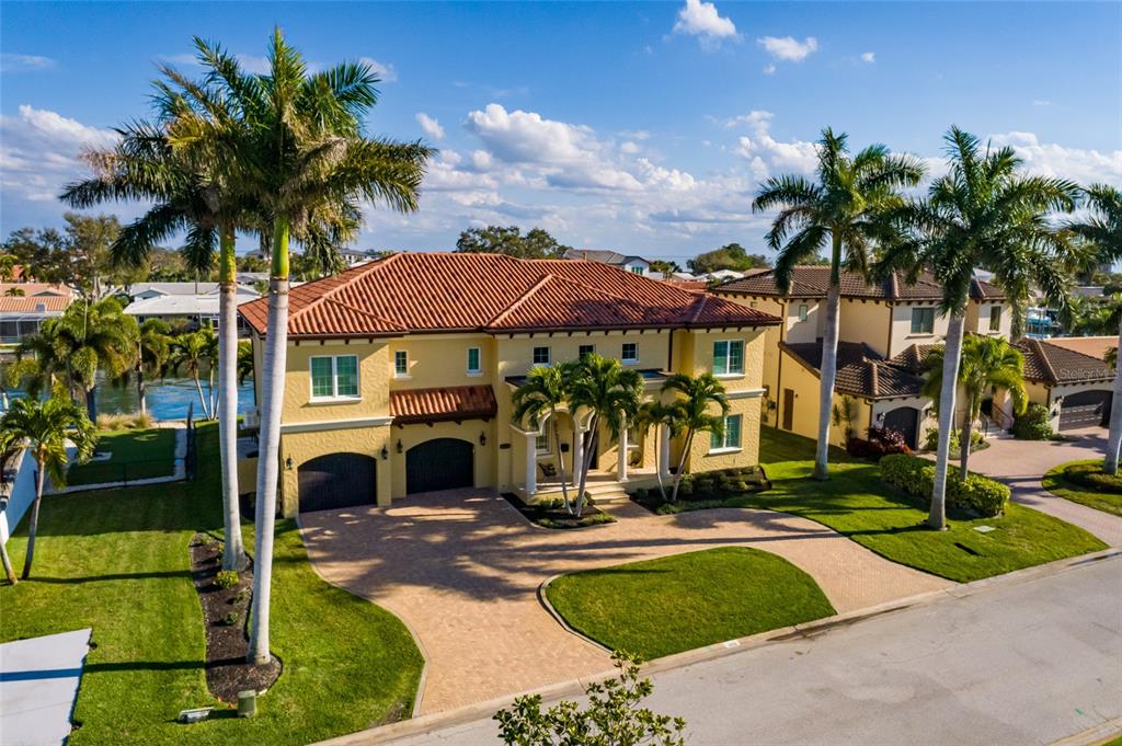 An aerial view shows a two-story yellow house with a tile roof and palm trees — 1976 KANSAS AVENUE NE, ST PETERSBURG, FL