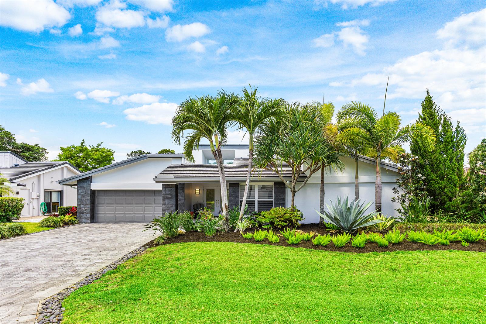 A single-story house with a gray garage, palm trees, and a landscaped front yard — 632 Lakewoode Circle W, Delray Beach FL 33445, DELRAY BEACH, FL