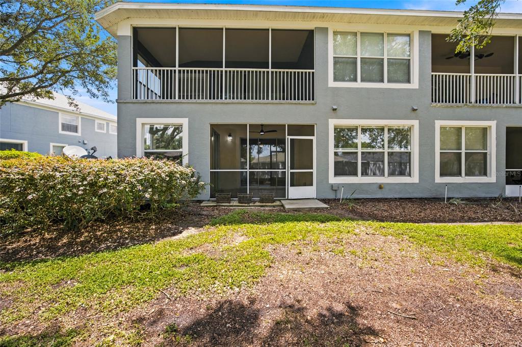 The exterior of a two-story residential building features a screened-in patio and large windows — 4550 SW 52ND CIRCLE UNIT 109, OCALA, FL