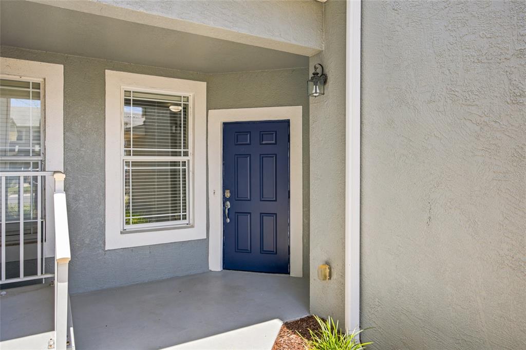 A blue front door and a window are visible on the covered porch of a house — 4550 SW 52ND CIRCLE UNIT 109, OCALA, FL