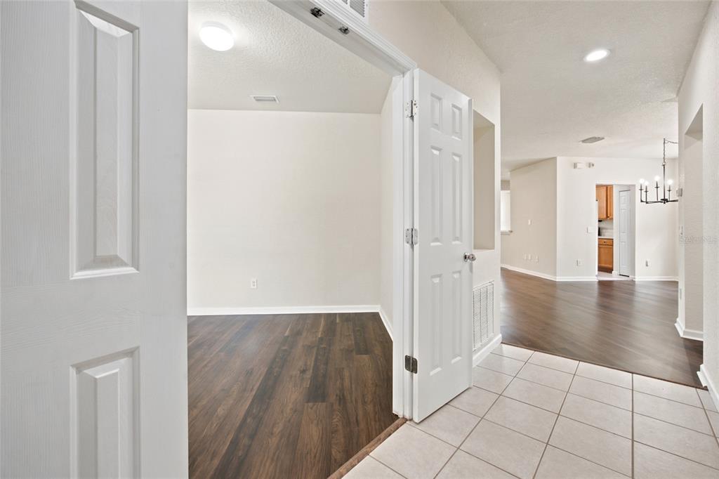 A room with dark wood-look flooring is visible through an open doorway from a tiled entryway — 4550 SW 52ND CIRCLE UNIT 109, OCALA, FL