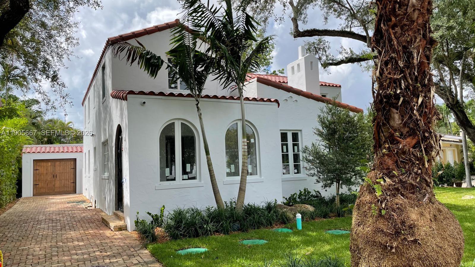 A white two-story Mediterranean-style house features a red tile roof and a brick driveway — 4100 Monserrate St, Coral Gables FL 33146, CORAL GABLES, FL