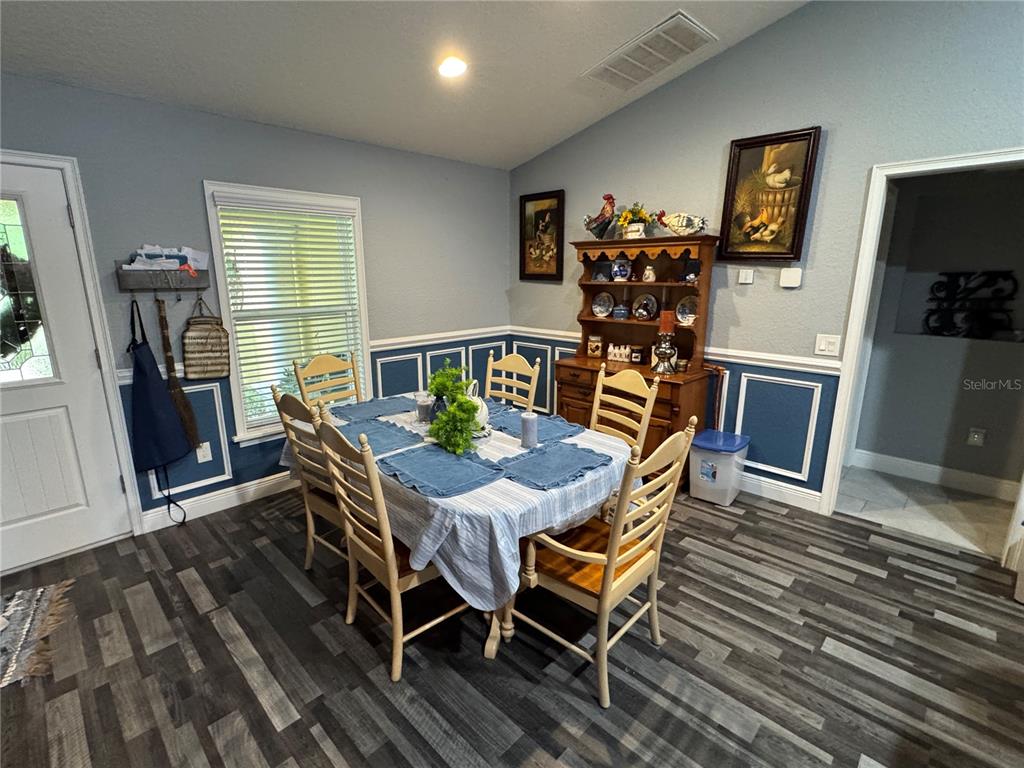 A dining room features a wooden hutch, a table with six chairs, and blue wainscoting — 16361 SE 80TH TERRACE, SUMMERFIELD, FL