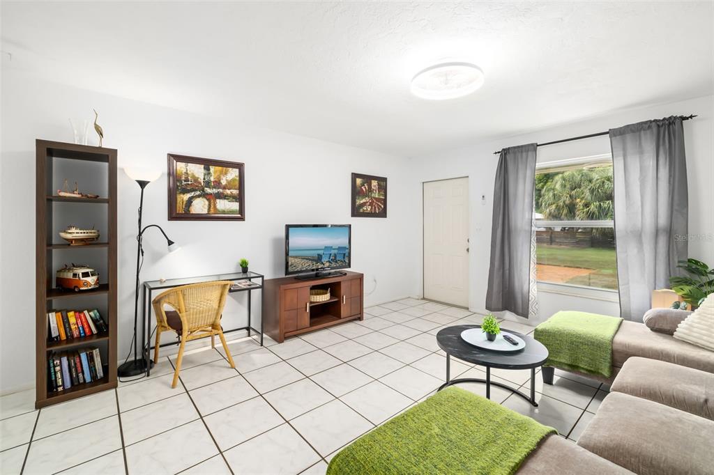 A living room features white tile floors, a gray sectional sofa, and a front door — 4001 GROVELAND AVENUE, SARASOTA, FL
