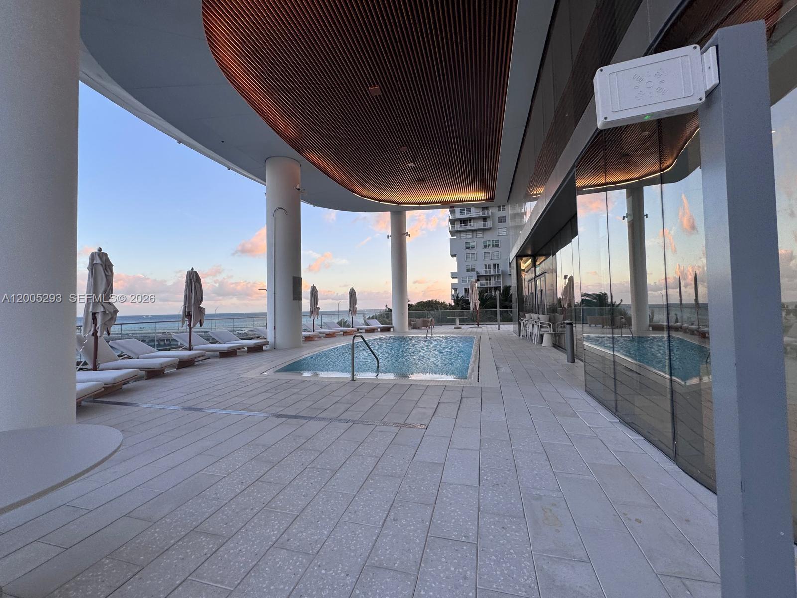 A pool deck features lounge chairs, a rectangular swimming pool, and a slatted wood ceiling — 175 se 25 rd # 2803, Miami FL 33129, MIAMI, FL