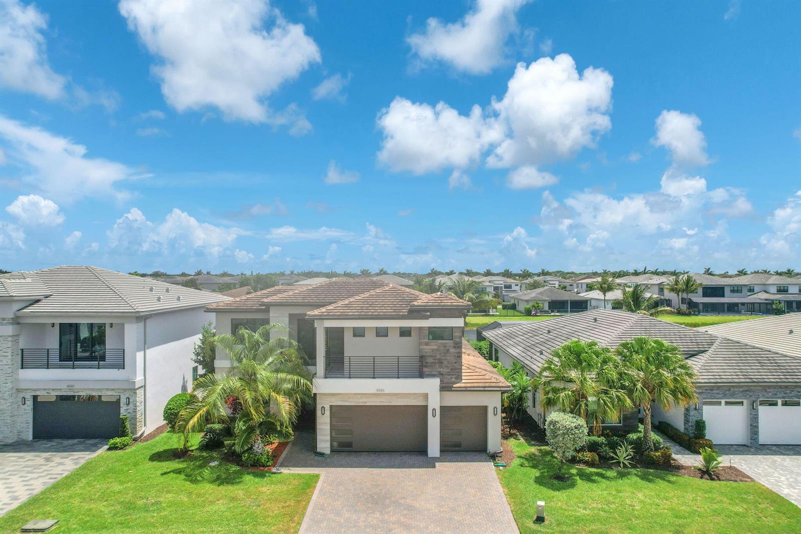 An aerial view shows a two-story suburban house with a paved driveway and palm trees — 8586 Dream Falls Street, Boca Raton FL 33496, BOCA RATON, FL
