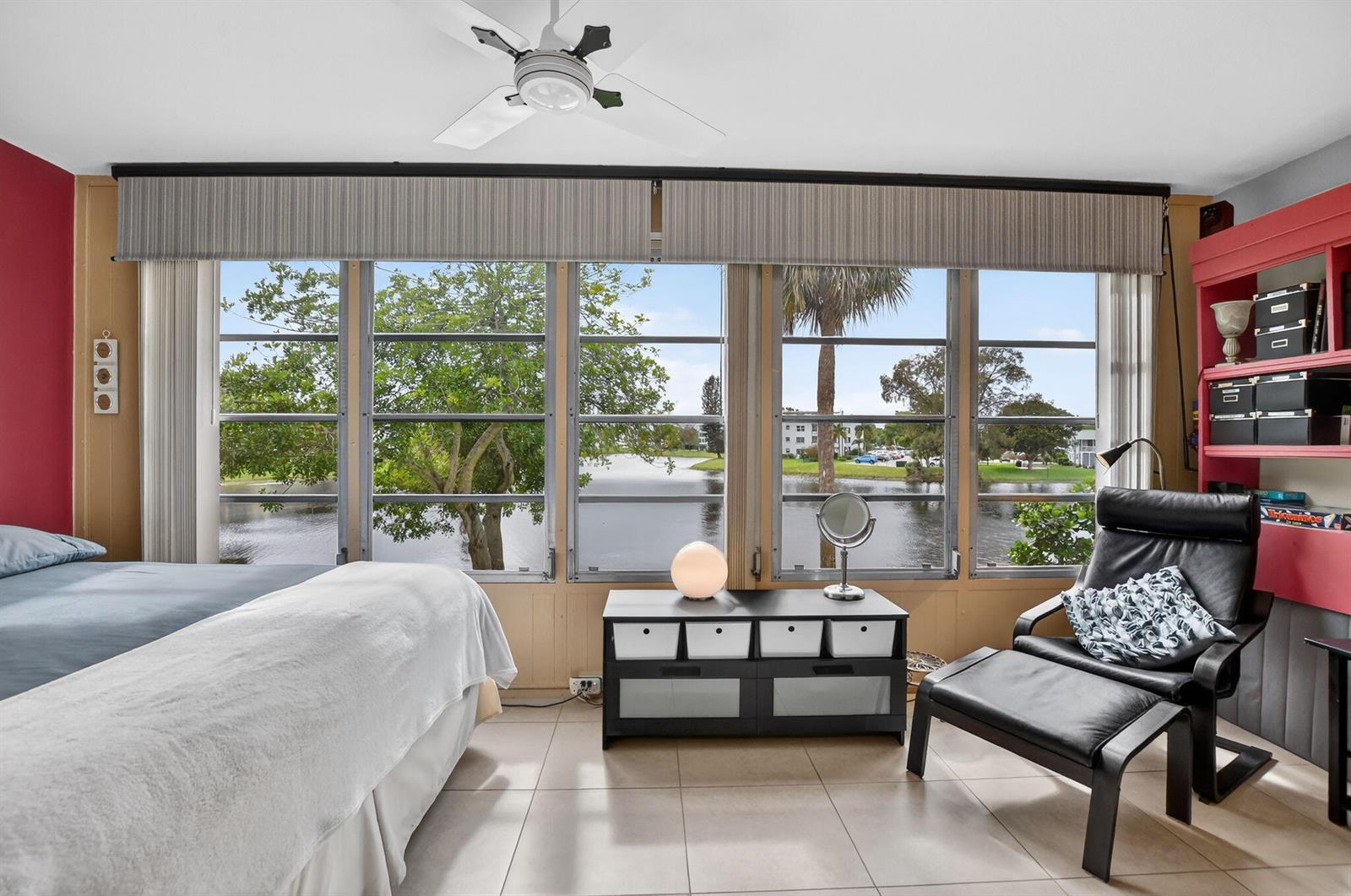 A bedroom features a bed with palm-print bedding, a chair, and a sliding door to a patio — 2010 N Farnham N, Deerfield Beach FL 33442, DEERFIELD BEACH, FL